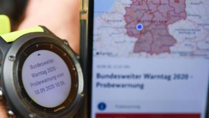 Bild: Arne Dedert/dpa
Auf dem Display einer Sportuhr, die neben ein Smartphone mit der geöffneten Katastrophenwarnungsapp "NINA" gehalten wird, steht die Information "Bundesweiter Warntag 2020 - Probewarnung vom 10.09.2020 10:56". Erstmals seit der Wiedervereinigung ist ein bundesweiter Probealarm ausgelöst worden.