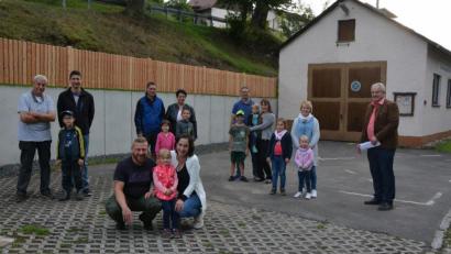 Bild: jr
Nahezu das ganze Dorf steht hinter der teilweisen Neugestaltung des Dorfmittelpunkts in Königshütte. Am Hang beim Feuerwehrhaus wurde eine neue Betonstützmauer gebaut, darauf wurde ein Zaun aus Lärchenholz gesetzt. Die Dorfbewohner und Bürgermeister Johann Burger (rechts) freuen sich über die Maßnahmen.