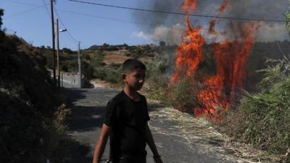 Bild: Petros Giannakouris/AP/dpa
Ein Junge geht in der Nähe eines kleinen Feuers auf einem Feld in der Nähe der Stadt Mytilene. Mehrere Tausend Migranten haben die vierte Nacht unter freiem Himmel verbracht, nachdem zwei aufeinanderfolgende Nächte mit Bränden in dem überfüllten Lager Moria sie obdachlos gemacht hatten.