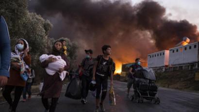 Bild: Socrates Baltagiannis/dpa
Moria, ein düsterer Ort: Migranten fliehen vor neu ausgebrochenen Feuern mit ihren Habseligkeiten aus dem Flüchtlingslager Moria, nachdem zuvor bereits mehrere Brände das Lager nahezu vollständig zerstört hatten.