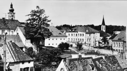 Bild: Archiv Franz Krapf, Repro Thomas Sporrer
Ein Blick in die „gute alte Zeit“, Ende der 50er Jahre. Aufgenommen von der Brauerei Schels aus sieht man vorne links den Völkl-Stadl mit Wagner-Werkstatt (der geöffnete große Türladen zur Regensburger Straße zeigt an, dass gearbeitet wird), daneben den kleine Garten. Die Fronfeste (Mitte) ist noch ein Gefängnis, bevor für mehr als 50 Jahre die Polizei einzieht. Im Kloster der Armen Schulschwestern (oben rechts) herrscht noch vielfältiges Leben, die Mädchenschule – untergebracht im Kloster und im jetzigen „MuseumsQuartier“ – ist noch die anerkannte Ausbildungsstelle für die jungen Damen.