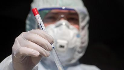 Bild: Stefan Sauer/dpa
Ein Mitarbeiter eines mobilen Abstrich-Zentrums zeigt ein nicht benutztes Abstrichstäbchen.