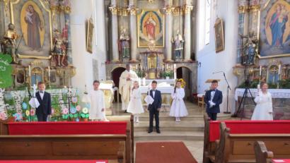 Bild: adj
Nach der Kirche präsentieren sich die Kommunionkinder mit Pfarrer Pennoraj Tharmakkan (hinten) vor dem Altar.