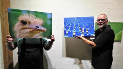 Bild: ubb
Die beiden Kunsthaus-Mitglieder Werner Müller (links hinter dem Vogel-Strauß-Foto) und Jürgen Klein (rechts) sind beim Bestücken der Ausstellung für kleine Scherze wie mit dem Vogel-Strauß-Foto immer gern bereit. Kunstfreunde dürfen sich freuen, in der Präsentation der Künstler gibt es viel Neues zu sehen, eindrucksvolle Werke werden gezeigt.