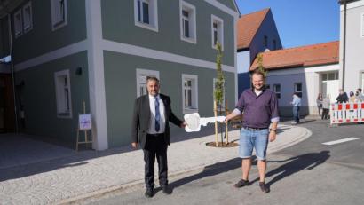 Bild: fvo
Bürgermeister Josef Beimler überreicht dem Mieter des revitalisierten alten Beimlschlosser-Hauses, Physiotherapeut Thomas Bauer (rechts), den Schlüssel für das Gebäude.