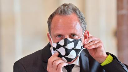 Bild: Peter Kneffel/dpa
Thorsten Glauber (Freie Wähler) nimmt sich zu Beginn einer Kabinettssitzung seinen Mund-Nasen-Schutz ab.