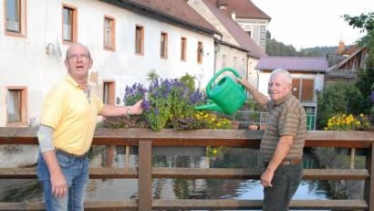 Bild: pop
Karl Scheuerer rechts im Bild pflegt wie viele andere Blumenpaten den Blumenschmuck, hier an der Hammerbrücke. 2. Vorsitzender des Gartenbauvereins Bernhard Tischler weiß dies Engagement zu schätzen.