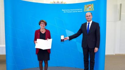 Bild: Bayerisches Staatsministerium der Finanzen und für Heimat
Die Weidenerin Waltraud Koller-Girke erhält von Minister Albert Füracker die Urkunde des Bundespräsidenten sowie das Bundesverdienstkreuz am Bande.