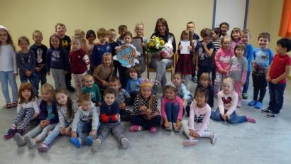 Bild: R. Kreuzer
Kinderpflegerin (Mitte, sitzend) feiert inmitten der Kinder ihr 25-jähriges Dienstjubiläum.