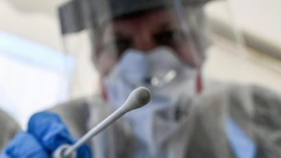 Bild: Britta Pedersen/dpa
Ein Abstrichstäbchen wird in die Kamera gehalten.