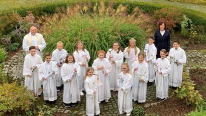 Bild: mez
Pfarrer Markus Bruckner und die stellvertretende Schulleiterin der Grundschule, Kerstin Zaus, zusammen mit den 14 gut gelaunten Erstkommunikanten im Pfarrgarten der Herz-Jesu-Pfarrei.