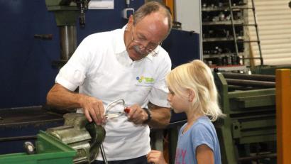 Archivbild: Hirsch
Eine der Veranstaltungen des Projekts "Technik für Kinder" fand im vergangenen Jahr im BBZ Schwandorf statt. Hier lässt sich die damals achtjährige Melissa von TfK-Mentor Max Birkeneder den Umgang mit der Säge zeigen.