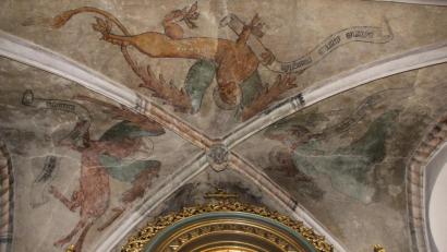 Bild: ads
Während des dritten Kirchenbaus von Gebenbach von 1412 bis 1415 sind die Gemälde von den Symbolen der vier Evangelisten an der Decke der Apsis der Pfarrkirche entstanden, die bis heute erhalten sind. Zentrum der Decke sind die Gewölbeschlusssteine der zwei Kreuzjoche, die das Haupt Christi und das Lamm Gottes tragen.