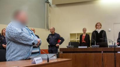 Bild: Peter Kneffel
Der Angeklagte (l) steht zum Prozessauftakt an seinem Platz im Gericht. Foto: Peter Kneffel/dpa/Archivbild