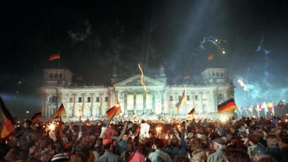 Archivbild: Jörg Schmitt/dpa
3. Oktober 1990, Berlin: Jubelnde Menschenmassen vor dem Berliner Reichstag, die mit Feuerwerk, Deutschlandfahnen und Volksfesttrubel die wiedergewonnene Einheit Deutschlands feiern.