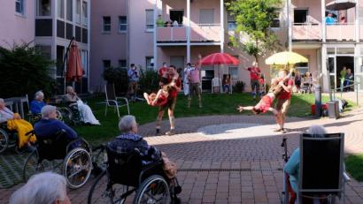 Bild: u
Auf Einladung des Förderkreises Altenhilfe gastieren die Burschen vom Neidaffer Plattlclub in der Gartenanlage des BRK-Seniorenheims St. Barbara. Für ihre teils akrobatischen Darbietungen bekommen sie tosenden Beifall, etwa als der Jackl den Kordl (links) und der Hias den Dammer (rechts) zu „Hulapalu“ von Andreas Gabalier (gemimt vom Beda, kariertes Hemd) durch die Luft kreisen lässt. Mit im Bild Moderator Fonse (rotes Shirt mit Mikrofon).
