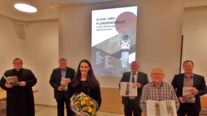 Bild: br
Knapp 250 Seiten mit 106 Denkmälern umfasst das Buch „Flur- und Kleindenkmäler im Gebiet der Gemeinde Speichersdorf“ des Heimatforschers Werner Veigl (Zweiter von rechts). Er stellte es im Dorfgemeinschaftshaus in Plössen zusammen mit (von links) Pfarrer Sven Grillmeier, Altbürgermeister Manfred Porsch, Simone Walter, Verleger Eckhard Bodner und Bürgermeister Christian Porsch der Öffentlichkeit vor.