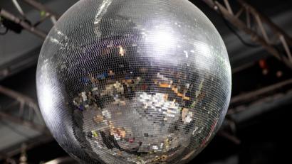 Symbolbild: Jens Büttner/dpa
In einer großen Discokugel spiegelt sich die leere Tanzfläche der geschlossenen Disco. Die Clubs müssen in der Corona-Pandemie weiterhin ausharren.