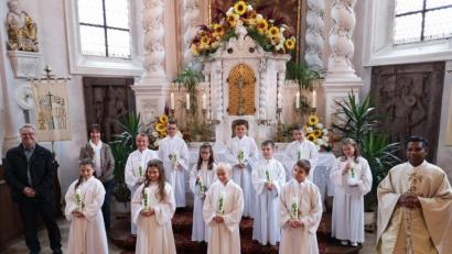 21 Kinder aus der Pfarrei feierten Erstkommunion in zwei Gruppen. Unser Bild zeigt eine der Gruppen zusammen mit Pfarrer P. Georg Parampilthadathil (rechts), Pastoralreferent Andreas Hartung (links) und der Religionslehrerin Reinhilde Bodensteiner (Dritte von links).
