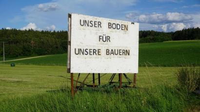 Bild: jut
"Unser Boden für unsere Bauern" steht als Protest auf einem Plakat geschrieben, das dort angebracht ist, wo ein 23 Hektar großer Solarpark entstehen sollte.