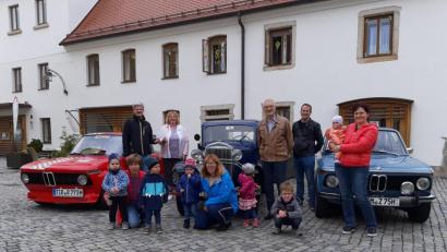 Bild: Birgit Mayer/exb
Hingucker am Kirchplatz: Zur Übergabe einer Spende an die Rappelkiste reihten Mitglieder des Oldtimer-Stammtischs Mitterteich einige historische Autos vor dem Mehrgenerationenhaus auf. Reinhard Dörschmidt überreichte das Geld an Birgit Mayer (hinten, von links). Mit dabei waren auch Alois Meierhöfer und Markus Kellner vom Stammtisch, Jeanette Beer, Marion Riedl und Carola Wölfl von der Rappelkiste sowie einige Kinder.