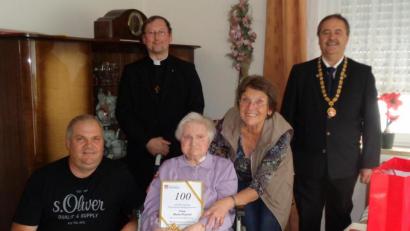 Bild: dpe
Maria Preischl (Mitte) feiert 100. Geburtstag, hier zusammen mit Enkel Gerhard und Tochter Marianne (vorn), Pfarrvikar Christian Preitschaft (hinten links) und Bürgermeister Peter Dotzler (rechts).