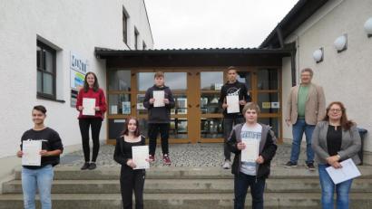 Bild: jzk
Schulleiter German Helgert (hinten rechts) und Englischlehrerin Cornelia Spies (rechts) gratulierten den Neuntklässlern zum bestandenen PET-Sprachtest.