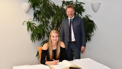 Bild: sche
Die deutsche Meisterin über 400 Meter, Corinna Schwab aus Hiltersdorf, trägt sich unter den Augen von Bürgermeister Alwin Märkl in das Goldene Buch der Gemeinde Freudenberg ein.