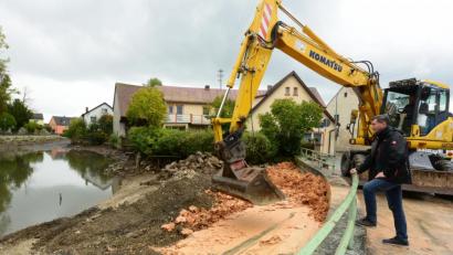 Bild: bey
Mit einem bindigen Lehmschlag wird der Uferbereich am Stadtweiher abgedichtet, um ein unkontrolliertes Absenken des Wasserspiegels zu verhindern. Bürgermeister Rainer Rewitzer, vom Berufsbild her mit Wasserbau bestens vertraut, hat diese altbewährte Methode des "Lehmschlages" als richtig für diese Maßnahme erachtet.