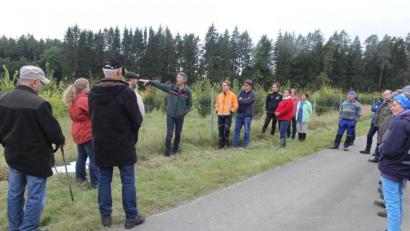 Bild: ral
Hermann Hartinger (graue Jacke) deutet auf sein Waldstück und stellt sein Projekt vor.