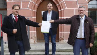Bild: mfh
Ein Klimaschutzzertifikat des Bundesumweltministeriums würdigt die Erfolge bei der Umrüstung der Straßenlampen in Sulzbach-Rosenberg. Von links Parlamentarischer Staatssekretär Florian Pronold, Elektromeister Roland Segerer und Bürgermeister Michael Göth.