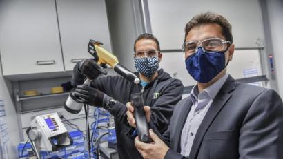 Bild: Florian Miedl/fph
Mit einer solchen Sprühpistole, wie sie Andreas Rank (links) hält, werden Kunststoffwerkstücke in der Hand von Felipe Wolff-Fabris lackiert.