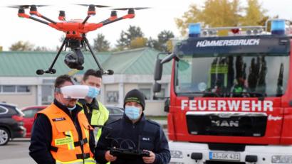 Bild: Wolfgang Steinbacher
Die Feuerwehr übt auf dem Parkplatz vor dem Kümmersbrucker Sportzentrum den Umgang mit der Drohne. Die ist schon abgehoben, der Pilot (rechts) steuert sie fern, der Beobachter (links) daneben hat die Bilder, die die Kamera unten am Copter aufnimmt, auf einer speziellen Brille direkt vor Augen.