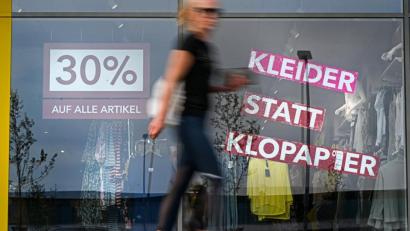 Bild: Felix Kästle/dpa
Eine Frau geht am Schaufenster eines Modegeschäfts vorbei, auf dem steht "30 Prozent auf alle Artikel" sowie "Kleider statt Klopapier". Werbung spielt oft mit Klischees.