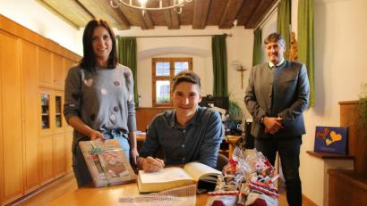 Bild: sne
Manuel Palecki trägt sich ins Goldene Buch der Stadt ein. Als Geschenk bekommt er von Bürgermeister Edgar Knobloch Laufschuhe und ein Buch über den Truppenübungsplatz, das seine Frau Stephanie stolz zeigt.