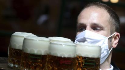 Symbolbild: Ronald Zak/dpa
Ein Kellner mit Maske trägt Bier auf einem Serviertablett (Symbolbild): In Amberg haben sich vor dem Lockdown nicht alle Wirte an diese und weitere Corona-Vorschriften gehalten.