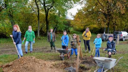 Bild: fdl
Mitglieder der Kindergruppe Naturkids pflanzen zusammen mit ihren Leiterinnen Sabine Siegert (hinten links) und Tanja Schumann (hinten rechts) sowie der Vorsitzenden Marion Schlosser (hinten Mitte) Bäume.