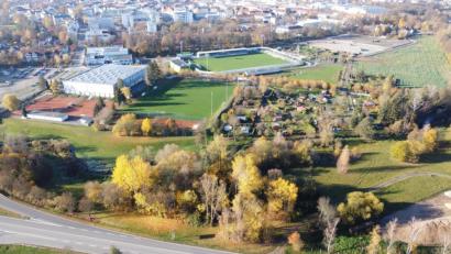 Bild: Gustl Beer
Direkt ans Wasserwerk-Stadion schließt das neue Funktionsgebäude an, dessen Bodenplatte bereits zu sehen ist. Jenseits der Erdhügel, die von der Bombentrichtersuche herrühren, entstehen die beiden Korkrasenplätze, an denen noch die Erdarbeiten laufen. Links die Mehrzweckhalle.