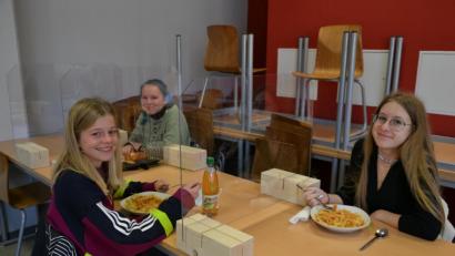 Bild: kaz
Marlene Züllich, Natalie Brandl und und Alina Grüner (von links) machen in der Mensa des Stiftland-Gymnasiums Mittagspause. Sie sind durch Plexiglasscheiben getrennt.