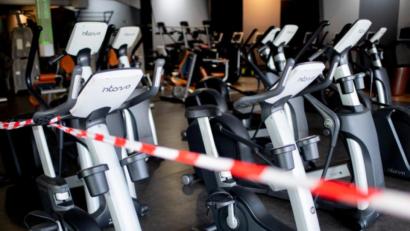 Bild: Hauke-Christian Dittrich/dpa
Ein rot-weißes Flatterband ist an Fahrradtrainern befestigt, die in einem Fitnessstudio stehen. Unter bestimmten Einschränkungen dürfen Studios bald wieder öffnen.