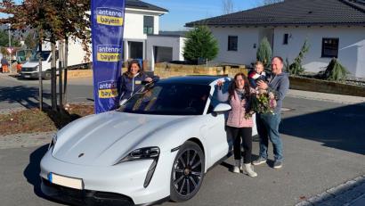 Bild: Nick Lisson/Antenne Bayern/exb
Familie Kaatzke strahlt. Marion Schieder, "die Schiederin" von Antenne Bayern (links), bringt den Eschenbachern einen Porsche Taycan zur Probefahrt vorbei. Mama Stefanie hat bei dem Radiosender so einen Flitzer in der Farbe blau gewonnen.