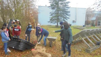 Bild: Mittelschule Mitterteich/exb
Im Garten der Mittelschule Mitterteich soll ein Feuchtbiotop entstehen. Unter fachkundiger Anleitung setzten die am Projekt beteiligten Jugendlichen eine Teichwanne und gestalteten die Uferzone.