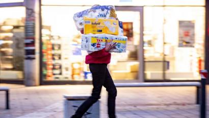 Bild: Axel Heimken
Ein Frau läuft mit dem Arm voller Klopapierrollen aus einem Drogeriemarkt heraus. Foto: Axel Heimken/dpa