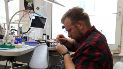 Bild: Susanne Forster
Uhrmacher Christopher Kreitl arbeitet mit kleinem Werkzeug, wenn er eine Uhr repariert. Manchmal braucht er eine Lupe, die er um seinen Kopf gespannt trägt, wenn er sie gerade nicht braucht.