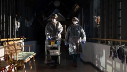 Bild: Sebastian Gollnow/dpa
Zwei Altenpflegerinnen testen Altenheimbewohner auf Corona. Die Fallzahlen bleiben weiter auffallend hoch.