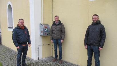Bild: fg
Schnelle Erste Hilfe kann der neue, an der Nordseite der Weiherer Dorfkirche angebrachte Defibrillator im Notfall darstellen. Ortssprecher Georg Ott freut sich mit Bürgermeister Hermann Falk und dem Vorsitzenden der Feuerwehr Weiher, Michael Reif, (von links) über den Defibrillator.
