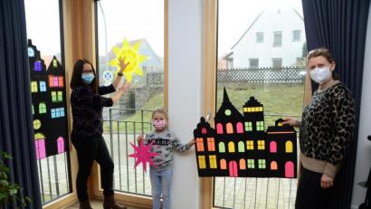 Bild: dob
Sonja Münchmeier (links) und Heidi Sollfrank mit Töchterchen Romy gestalteten zum ersten Adventswochenende das erste Fenster im Pfarrheim St. Marien, das jeden Abend mit Licht angestrahlt wird. Jede Woche kommt ein weiteres Fenster hinzu.
