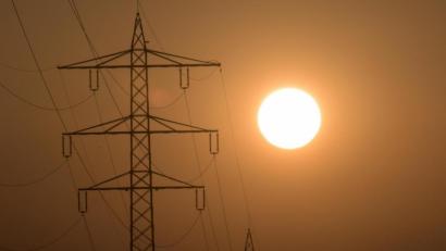 Bild: Patrick Seeger/dpa
Die Sonne geht hinter einem Strommasten unter.