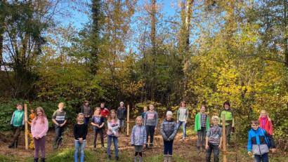 Bild: ral
Die Kommunionkinder sind nach der Pflanzaktion stolz auf ihre getane Arbeit.