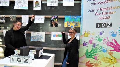 Bild: ubb
Charlotte Zintl und Marleen Stock haben viel Spaß beim Aufhängen der Kinderbilder im Foyer des IGZ-Hauptgebäudes.